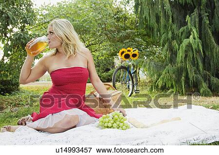 Woman drinking from jar at picnic View Large Photo Image Stock Photo - Woman drinking from jar at picnic. Fotosearch