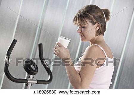 Woman drinking milk in home gym View Large Photo Image Stock Image - Woman drinking milk in home gym. Fotosearch
