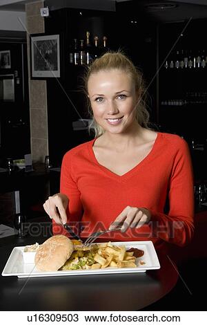 Woman eating plate of food in cafe View Large Photo Image Stock Image - Woman eating plate of food in cafe. Fotosearch