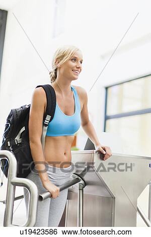 Stock Photograph - Woman entering through turnstile. Fotosearch