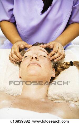 Stock Image - Woman having scalp massage in spa. Fotosearch