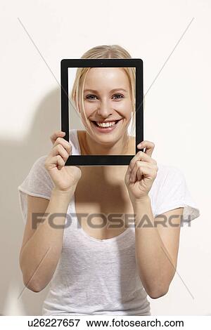 Woman holding picture of her face View Large Photo Image Stock Photo - Woman holding picture of her face. Fotosearch
