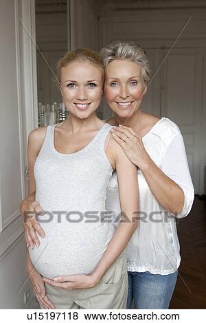 Stock Photo - Woman hugging pregnant daughter. Fotosearch