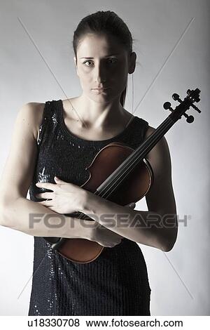 Stock Photo - Woman in town holding violin. Fotosearch