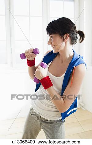 Woman lifting weights indoors View Large Photo Image Stock Photo - Woman lifting weights indoors. Fotosearch