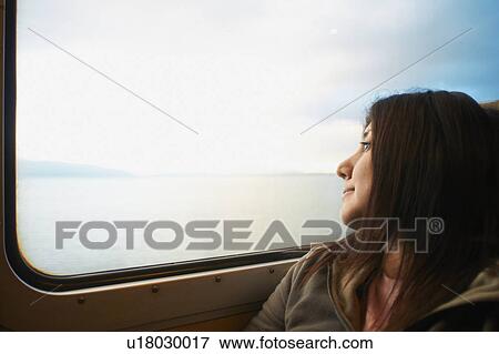 Woman looking out train window View Large Photo Image Stock Photo - Woman looking out train window. Fotosearch