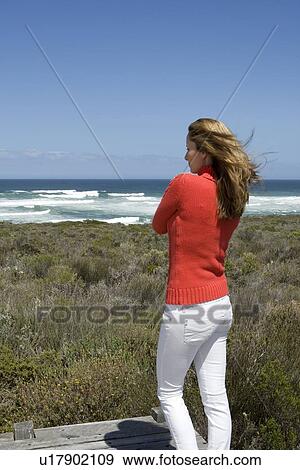 Stock Photo - Woman overlooking windy beach. Fotosearch