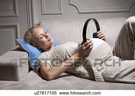 Stock Photography - Woman playing music for pregnant belly. Fotosearch