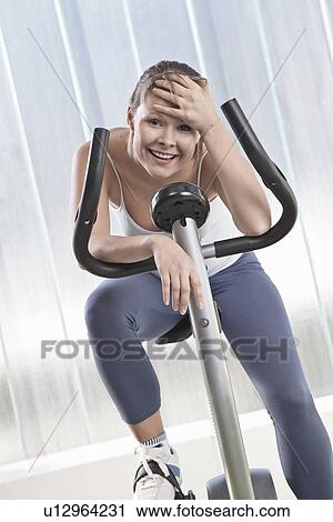 Woman resting on exercise machine View Large Photo Image Stock Image - Woman resting on exercise machine. Fotosearch