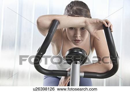 Woman resting on exercise machine View Large Photo Image Stock Photograph - Woman resting on exercise machine. Fotosearch