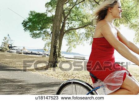 Woman riding bicycle on rural road View Large Photo Image Stock Image - Woman riding bicycle on rural road. Fotosearch