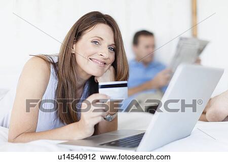 Woman shopping online on bed View Large Photo Image Stock Image - Woman shopping online on bed. Fotosearch