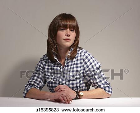 Stock Image - Woman sitting at desk. Fotosearch