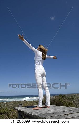 Woman standing on wooden pier View Large Photo Image Stock Photo - Woman standing on wooden pier. Fotosearch
