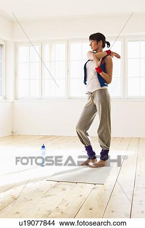 Picture - Woman stretching before yoga in studio. Fotosearch