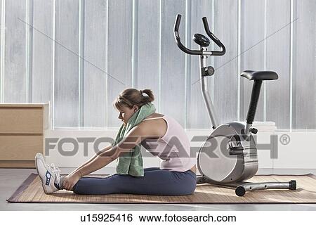 Woman stretching by exercise machine View Large Photo Image Stock Photograph - Woman stretching by exercise machine. Fotosearch