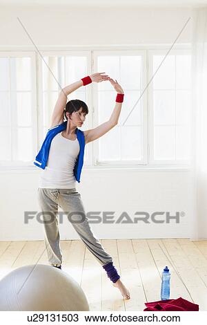 Stock Image - Woman stretching during workout. Fotosearch