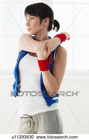 Stock Image - Woman stretching indoors. Fotosearch