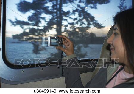 Woman taking pictures at train window View Large Photo Image Stock Photo - Woman taking pictures at train window. Fotosearch