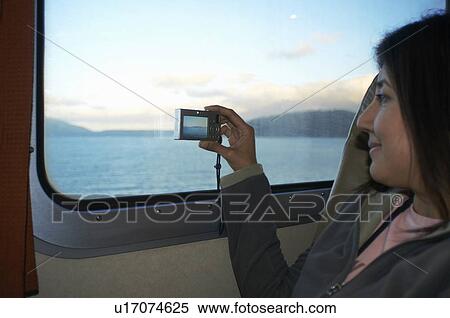 Stock Photography - Woman taking pictures at train window. Fotosearch