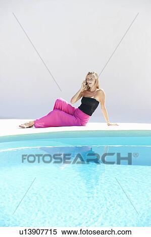 Woman using cell phone by pool View Large Photo Image Stock Photography - Woman using cell phone by pool. Fotosearch