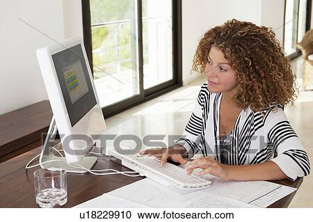 Woman using computer at desk View Large Photo Image Stock Image - Woman using computer at desk. Fotosearch