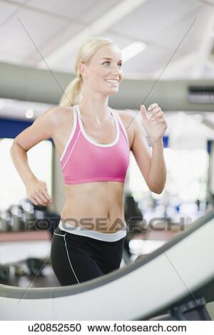 Woman using exercise machine in gym View Large Photo Image Stock Image - Woman using exercise machine in gym. Fotosearch