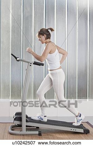 Woman using exercise machine View Large Photo Image Stock Photo - Woman using exercise machine. Fotosearch