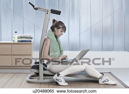 Woman using laptop on exercise machine View Large Photo Image Stock Photography - Woman using laptop on exercise machine. Fotosearch