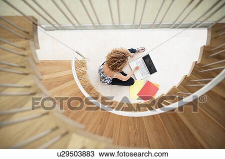 Stock Image - Woman using laptop on floor. Fotosearch