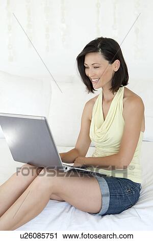 Woman using laptop on sofa View Large Photo Image Stock Image - Woman using laptop on sofa. Fotosearch