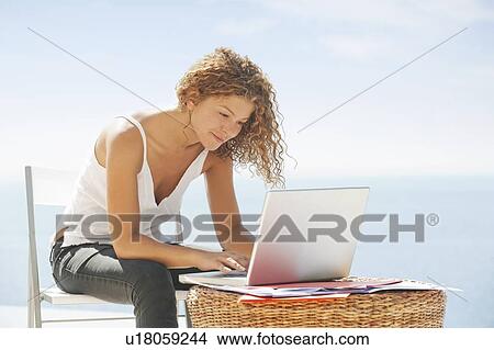 Picture - Woman using laptop outdoors. Fotosearch