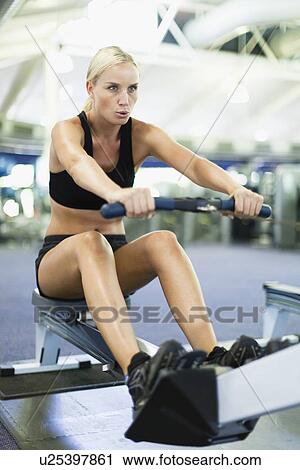 Woman using rowing machine in gym View Large Photo Image Stock Image - Woman using rowing machine in gym. Fotosearch