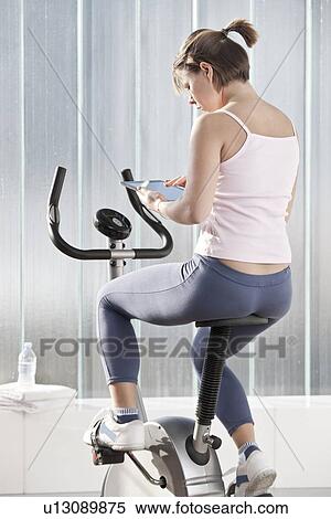 Stock Photography - Woman using tablet computer in workout. Fotosearch