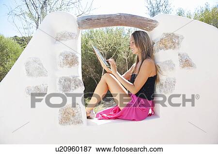 Stock Photo - Woman using tablet computer outdoors. Fotosearch