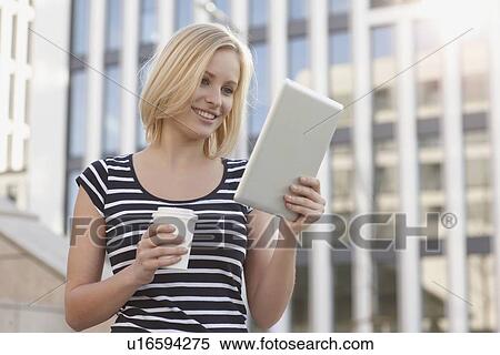 Stock Photography - Woman using tablet computer outdoors. Fotosearch