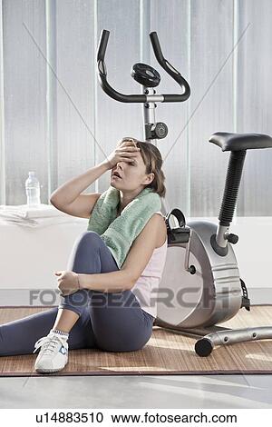 Woman wiping sweat by exercise machine View Large Photo Image Stock Image - Woman wiping sweat by exercise machine. Fotosearch
