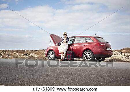 Stock Photo - Woman with broken down car on rural road. Fotosearch