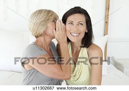 Women whispering to each other View Large Photo Image Stock Photo - Women whispering to each other. Fotosearch