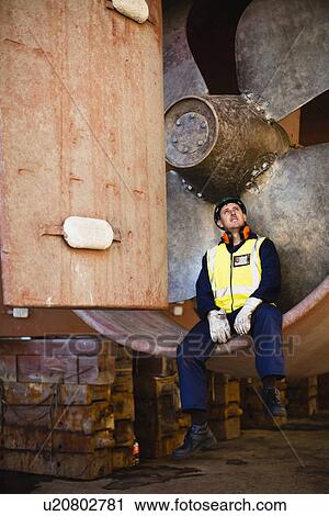 Worker sitting in propeller on dry dock View Large Photo Image Stock Image - Worker sitting in propeller on dry dock. Fotosearch