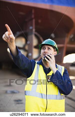 Worker using walkie talkie on dry dock View Large Photo Image Stock Image - Worker using walkie talkie on dry dock. Fotosearch