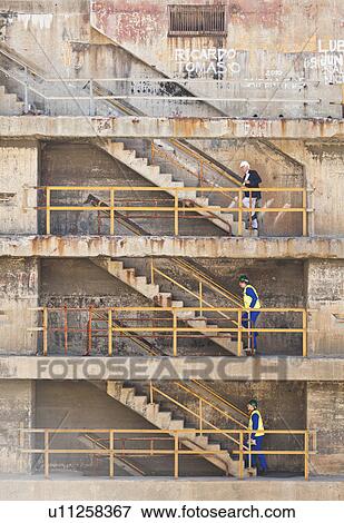 Stock Photo - Workers climbing steps on dry dock. Fotosearch