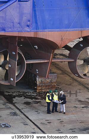 Workers reading blueprints at dry dock View Large Photo Image Stock Photo - Workers reading blueprints at dry dock. Fotosearch