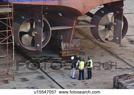 Workers reading blueprints at dry dock View Large Photo Image Stock Photo - Workers reading blueprints at dry dock. Fotosearch