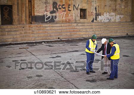 Workers reading blueprints on dry dock View Large Photo Image Stock Image - Workers reading blueprints on dry dock. Fotosearch