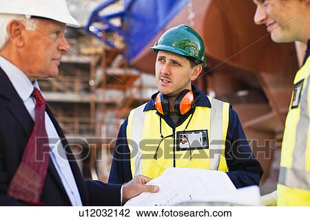Workers reading blueprints on dry dock View Large Photo Image Stock Image - Workers reading blueprints on dry dock. Fotosearch