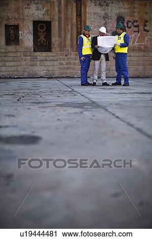 Workers reading blueprints on dry dock View Large Photo Image Stock Image - Workers reading blueprints on dry dock. Fotosearch