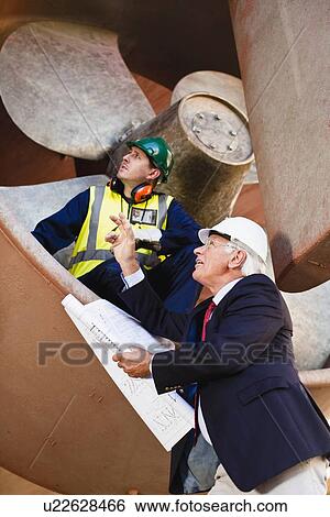 Stock Photograph - Workers talking in propeller on dry dock. Fotosearch