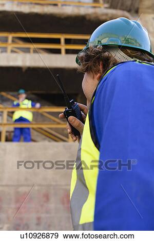 Stock Photo - Workers using walkie talkies on dry dock. Fotosearch