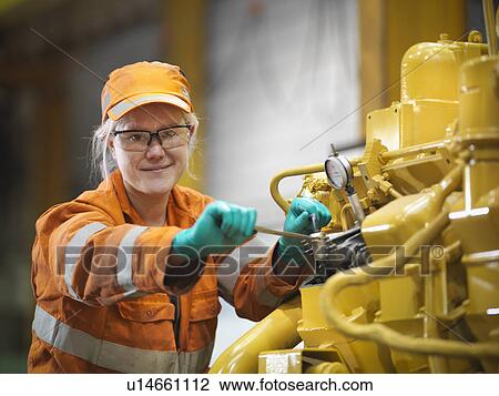 Stock Image - Apprentice engineer at work in factory. Fotosearch